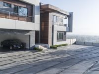 the exterior and landscape of a modern house in los angeles, california with stone and wood