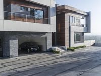 the exterior and landscape of a modern house in los angeles, california with stone and wood