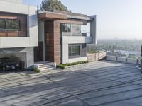 the exterior and landscape of a modern house in los angeles, california with stone and wood