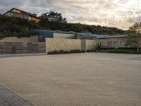 an outdoor concrete driveway with a large brick wall and wood fence to the side of the driveway