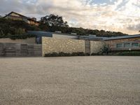 an outdoor concrete driveway with a large brick wall and wood fence to the side of the driveway