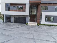 the exterior and landscape of a modern house in los angeles, california with stone and wood