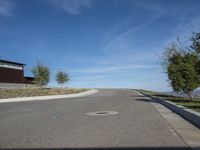 an empty street and parking lot, on a clear day in the desert, with no cars