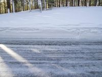 a skier stands at the edge of a slope where a snow bankers have plowed