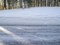 a skier stands at the edge of a slope where a snow bankers have plowed