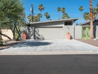 a modern palm desert style house with concrete driveway and tree lined path at the side of the home