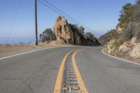 the road that is very narrow and the yellow markings are the road markings for a mountain