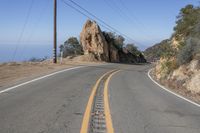 the road that is very narrow and the yellow markings are the road markings for a mountain