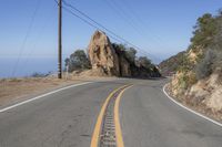 the road that is very narrow and the yellow markings are the road markings for a mountain