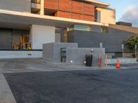 the building that houses a residence and a parking lot is built into concrete and has red caution cones