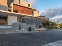 the building that houses a residence and a parking lot is built into concrete and has red caution cones