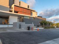 the building that houses a residence and a parking lot is built into concrete and has red caution cones