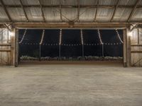 a barn filled with lots of lights in a room of wood flooring and metal ceiling