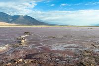 there is an empty lake with rocks scattered about it in the middle of the desert