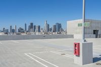 empty parking spaces next to the city skyline with two red fire hydrant boxes beside