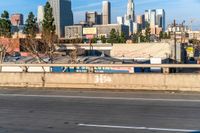 the back of a car drives down the highway in front of a large city skyline