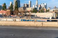 the back of a car drives down the highway in front of a large city skyline