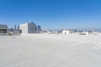 a parking lot next to a building with a city skyline in the background at the foreground