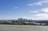 an adult woman with sunglasses riding a motorcycle and looking at a city skyline from a viewpoint