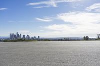 an adult woman with sunglasses riding a motorcycle and looking at a city skyline from a viewpoint