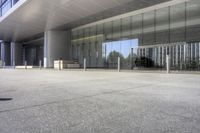 an empty parking lot with a building in the background on a sunny day with clear windows