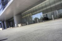 an empty parking lot with a building in the background on a sunny day with clear windows