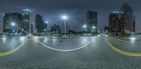 street with cars and skyscrapers at night near cityscape in nighttime time taken with fish eye lens