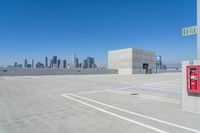 a parking lot with lots of parking spaces on top of it with buildings in the background