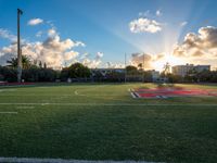 a soccer field with grass and other buildings in the background at sunset in miami, florida