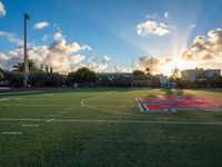 a soccer field with grass and other buildings in the background at sunset in miami, florida