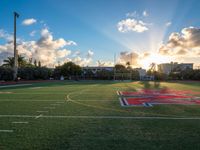 a soccer field with grass and other buildings in the background at sunset in miami, florida