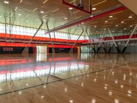 an indoor gymnasium with wood floors and lots of lights on it with an orange wall