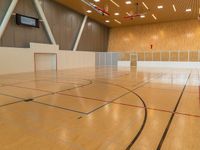 a sports gymnasium with a wooden floor and white walls with a goalie ball in the middle of the court