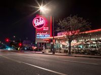 this is a picture of an american food store in california city by night on a city street