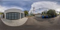 the fish - eye lens photo shows a view of a small garage and several trash bins