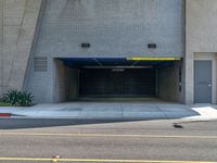 an empty building has a parking garage with yellow lights and a blue cover over it