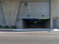 an empty building has a parking garage with yellow lights and a blue cover over it