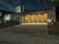 a large garage is shown outside at night time and lit up in lights, along with the palm trees