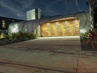a large garage is shown outside at night time and lit up in lights, along with the palm trees