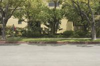 a building with many trees near by and on the street side of it with two buildings