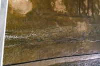 a person laying on the side of a cement wall with an umbrella in hand and another standing near