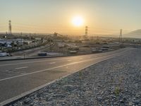 sunset over an intersection in an empty lot with no vehicles on it but the lights on