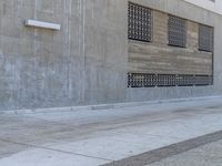 a man walking on sidewalk in front of a building while holding a blue bag and smoking