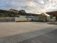 an outdoor courtyard with lots of parking space on the side of it with a sky background