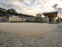 an outdoor courtyard with lots of parking space on the side of it with a sky background