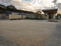 an outdoor courtyard with lots of parking space on the side of it with a sky background