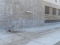 a red fire hydrant next to an old building with the windows closed and some concrete wall