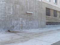 a red fire hydrant next to an old building with the windows closed and some concrete wall