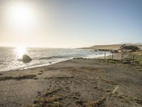 a grassy field by the shore and a cliff with rocks in the ocean in the background