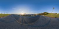 the sun is reflecting off of the camera lens on a road that has a grassy hill below